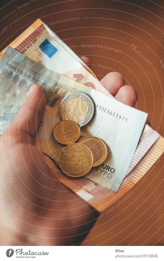 Eine Person die Euro Geldscheine und Münzen in der Hand hält Scheine halten geben Finanzen Trinkgeld bezahlen Geldmünzen Kapitalwirtschaft Bargeld bar bezahlen