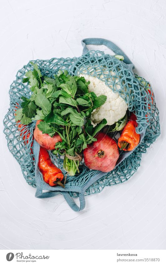 Flatlay aus abfallfreiem, nachhaltigem Lebensmitteleinkauf, verschiedenen Obst-, Gemüse- und Gemüsesorten in einem blauen Netzbeutel Essen Bestandteil Lifestyle