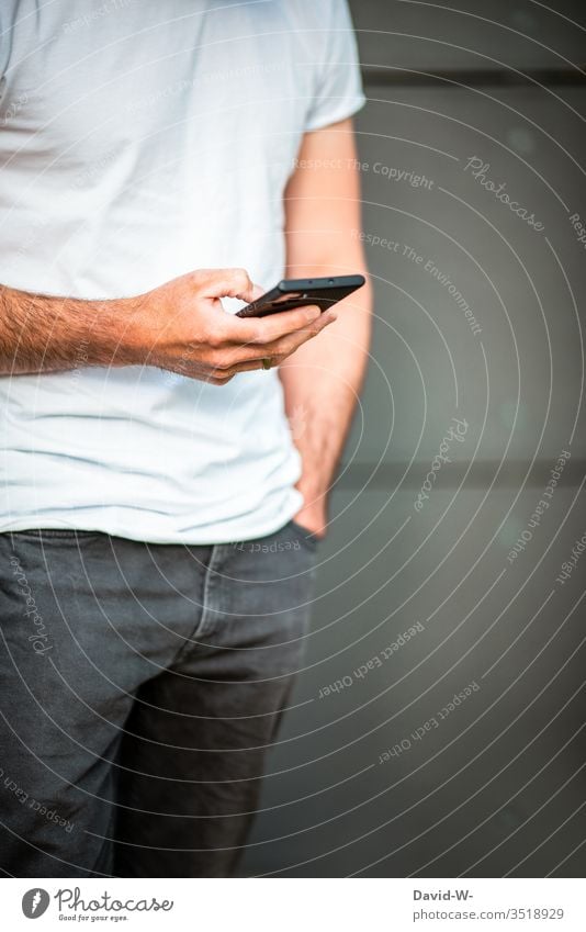 Mann benutzt sein Handy haltend Tippen Sucht suchtgefahr Informationstechnologie Internet Mobilität schreiben Nachricht Message Finger lässig Junger Mann