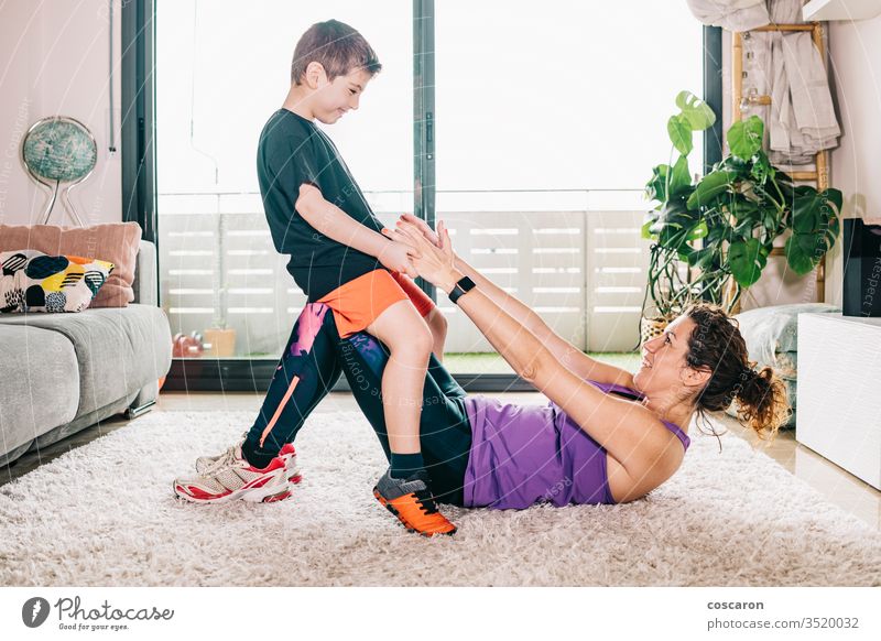 Kleiner Junge hilft seiner Mutter beim Sport aktiv Aktivität Erwachsener schön Pflege Kaukasier Kind Kindheit Coronavirus covid-19 Energie Übung Familie Frau
