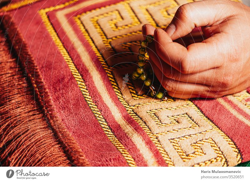 In der Hand haltender muslimischer Rosenkranz zum Mattengebet im Ramadan Kareem arabisch Kunst Hintergrund Buch Kultur Design dhikr dua Osten Glaube Fasten