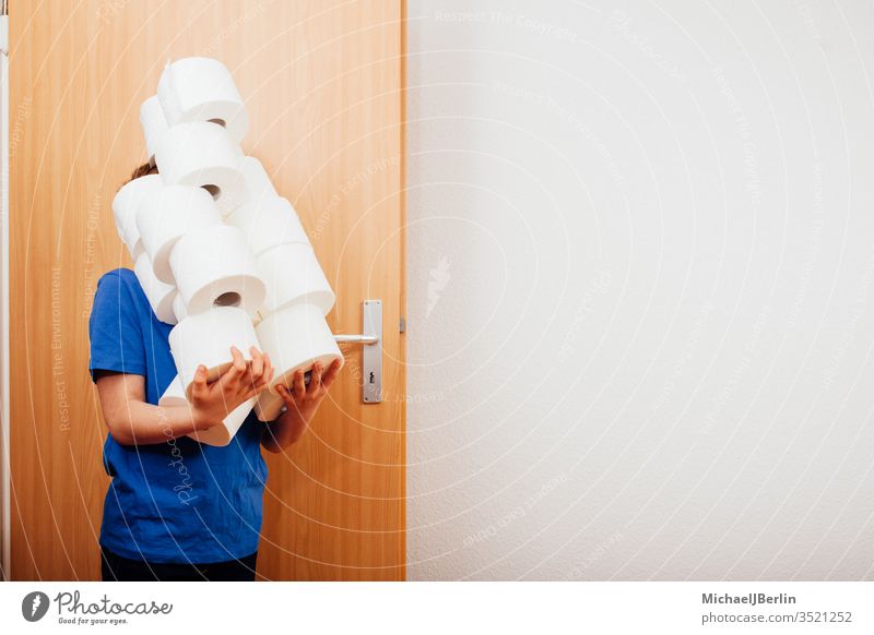 Junge bringt einen Stapel Toilettenpapier ins Zimmer übrig Kind Korona covid-19 Seuche Hamsterer Hamsterkauf heimwärts Ausbruch Pandemie Menschen Person privat