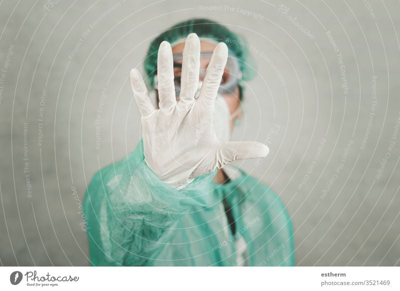 Coronavirus stoppen.ärztlicher Angestellter Arzt zeigt ein Stoppschild mit verschwommenem Hintergrund Virus Seuche Pandemie Quarantäne covid-19 Symptom Medizin