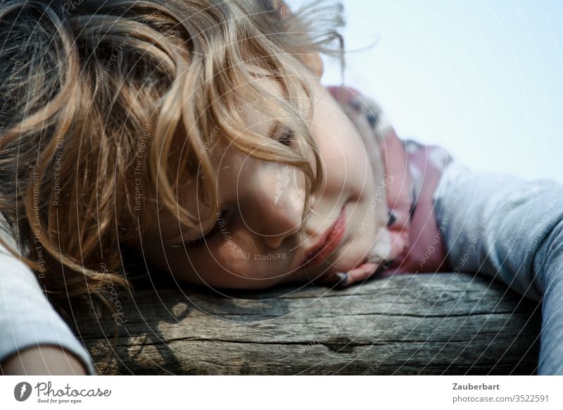 Kleines Mädchen lehnt mit geschlossenen Augen über einem Holzgeländer und träumt Kind Kindheit ausruhen Traum Porträt süß blond ruhig Vertrauen Gesicht Haare