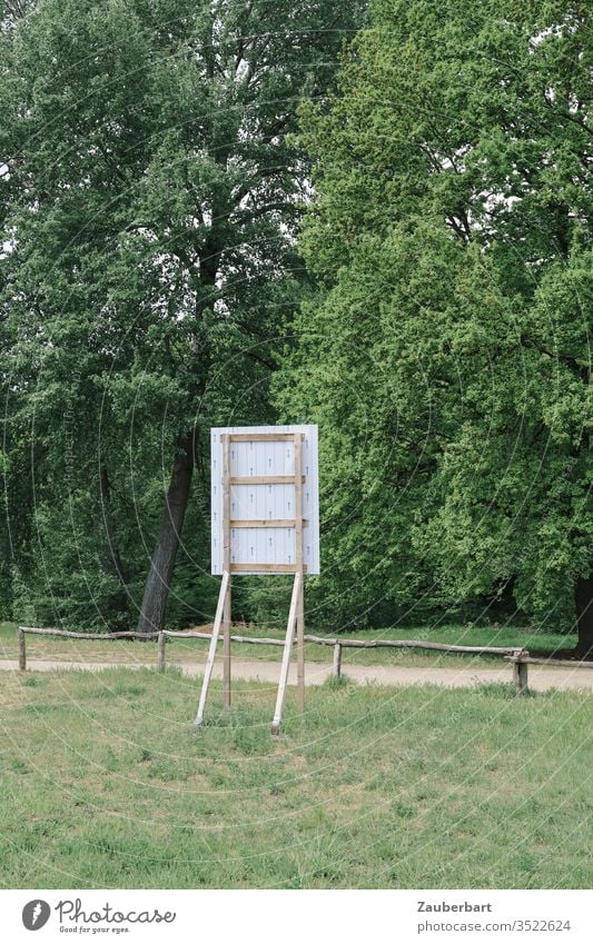 Rückseite eines Bauschilds auf natürlicher Wiese vor einem niedrigen Zaun Schild Natur Bäume Weg Landschaft Baustelle grün Umwelt stehen Tafel Gestell
