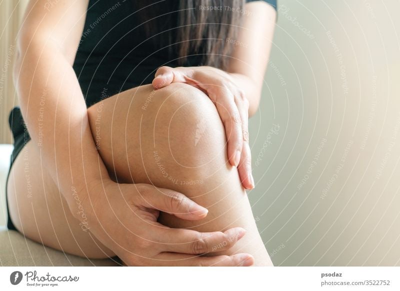 Frauen Knie schmerzhaft, Frauen berühren das schmerzhafte Knie zu Hause Unfall Schmerzen Fußknöchel Arthritis Asien Athlet Schönheit Körper Knochen gebrochen