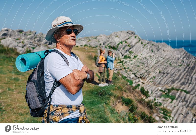 Ein älterer Mann beim Trekking mit Blick auf die Landschaft Wanderer Senior in den Ruhestand getreten Natur Hut Sonnenbrille Sommer Wanderung Berge u. Gebirge