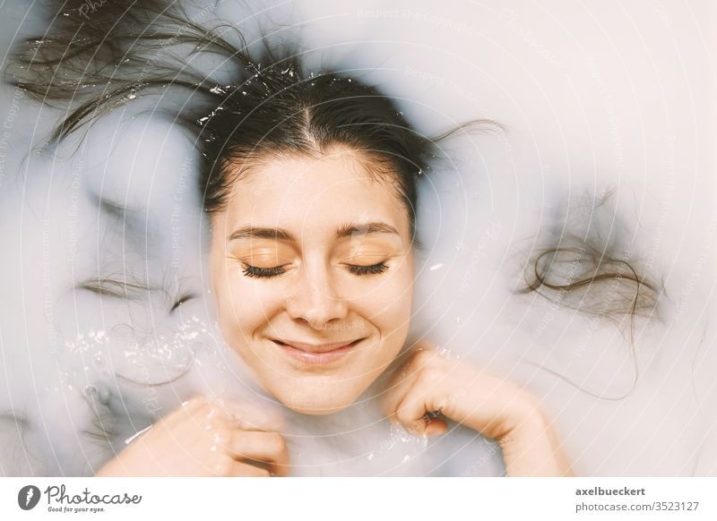 glückliche junge Frau, die ein Bad in Milch nimmt milchbad Baden Badewanne Wohlbefinden Selbstfürsorge Glück verwöhnen Schönheit Porträt Pflege Gesundheit