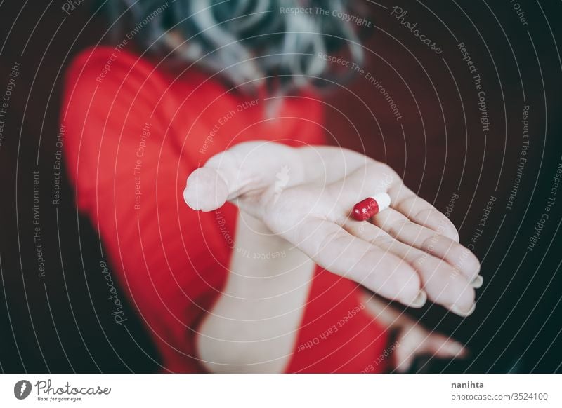 Junge Frau hält in der Hand eine weiß-rote Pille Tablette Medikament Medizin Virus Süchtige süchtig machend Sucht Schmerztablette Schmerzmittel abschließen