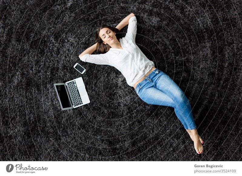 Junge Frau liegt auf dem Teppich Verlegung legen Rücken Laptop Stock Mädchen Telefon charmant Freizeit Ansicht rot Europäer Erwachsener Menschen Kaukasier