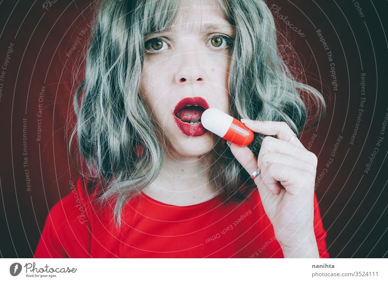 Junge Frau hält eine Riesenpille in den Händen medizinisch Medizin Tablette Medikament Süchtige Sucht Konzept Misstrauen Idee Entwurf konzeptionell rot weiß