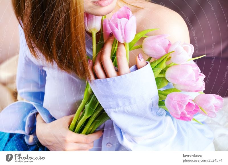 Nahaufnahme der Hände einer Frau, die einen Strauss rosa Tulpen halten pj Hemd blau Unschuld Schulter Porträt Ton-Bild Morgen präsentieren rot romantisch