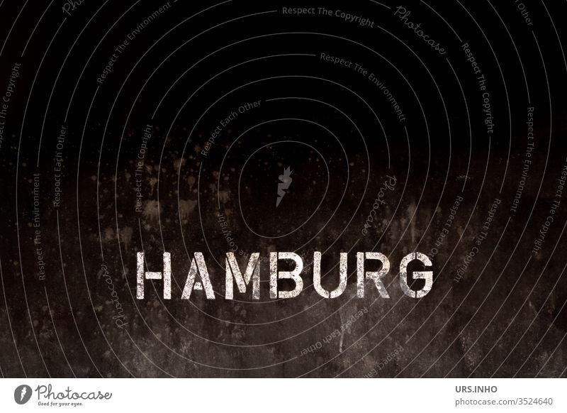 Text Hamburg als weiße Schriftzeichen auf einem  strukturierten Hintergrund in schwarz Schiffsrumpf Großbuchstaben Struktur geschrieben aufgedruckt Stadt