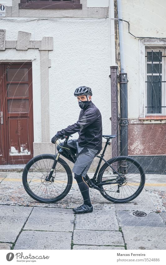 erwachsener Mann mit Fahrrad in der Stadt mit Maske Sport Viren Corona-Virus Atemwegserkrankungen Gesichtsmaske außerhalb COVID Kaukasier Gesundheitswesen