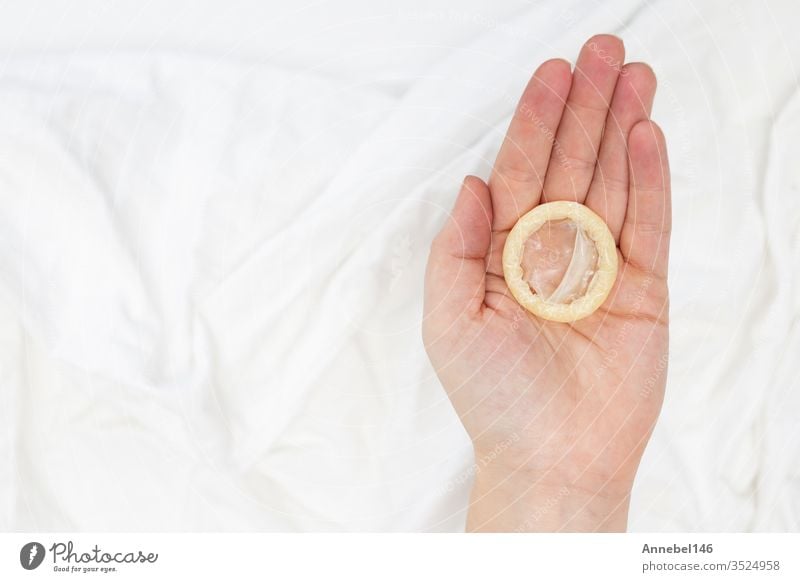 Konzept des sicheren Geschlechtsverkehrs. In der Hand ein Kondom mit weißem Laken haltend Sex Schutz AIDS Gesundheit Kontrolle Verhütung Verhütungsmittel HIV