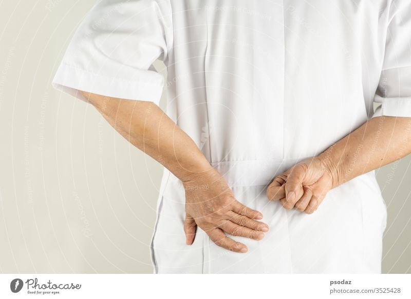 leitende Ärztin Frau mit Rückenschmerzen, Berührung des Rückens mit der Hand, Muskelschmerzen auf weißem Hintergrund Schmerzen Erwachsener gealtert schön Körper