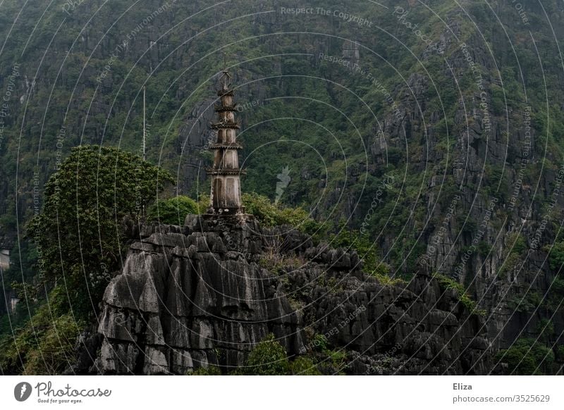 Architektur und Natur | Turm auf Kalksteinfelsen in der Landschaft von Ninh Binh in Vietnam grün alt Asien hoch