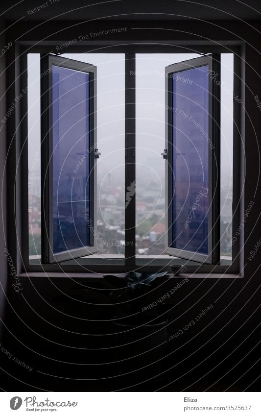 Ein geöffnetes Fenster mit getönten Fensterscheiben und Ausblick nach draußen offen lila Stadt Blick umrahmt Menschenleer Gebäude neblig Flügelfenster Hochhaus