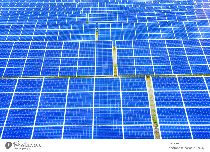Solarpanel auf blauem Himmel Hintergrund, alternatives Konzept für saubere grüne Energie. Luftaufnahme von Sonnenkollektoren Photovoltaikanlagen Industrielandschaft