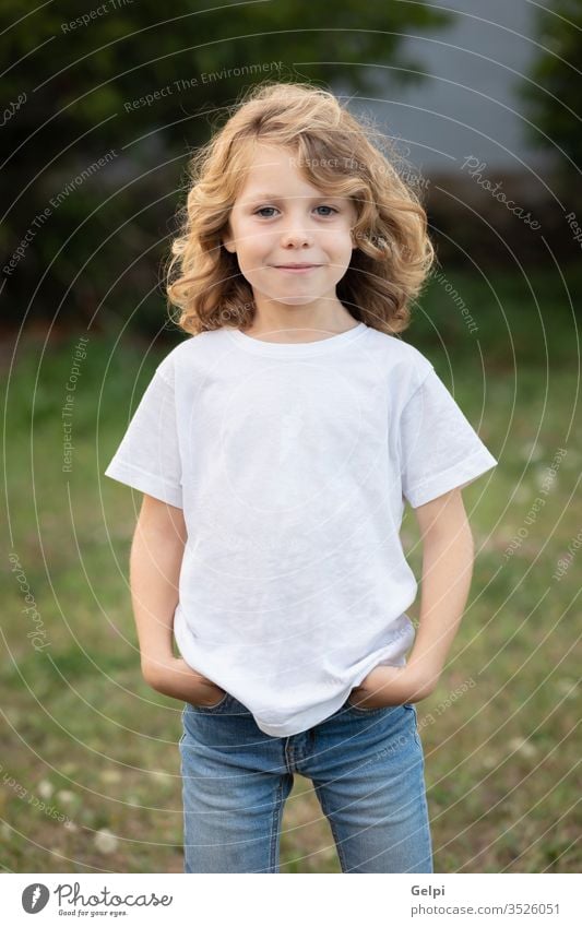 Lustiges blondes Kind mit langen Haaren. außerhalb eine Kindheit Menschen Kaukasier Freude Junge wenig Natur Behaarung wellig spielen Sommer jung im Freien Spaß