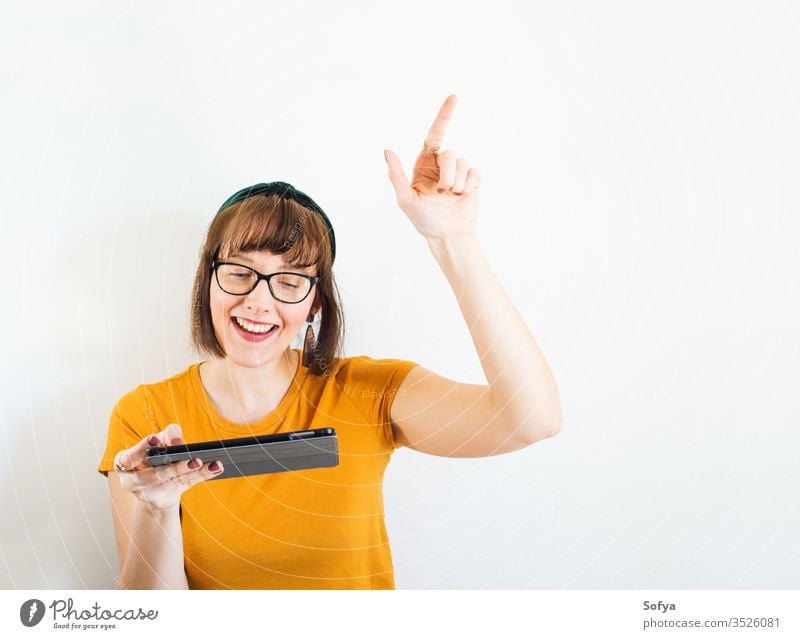 Lächelnde junge Frau in Gelb mit Tablette. online kaufen Person benutzend Mobile Schüler Lifestyle Quarantäne Schule Erwachsener zu Hause bleiben klug niedlich