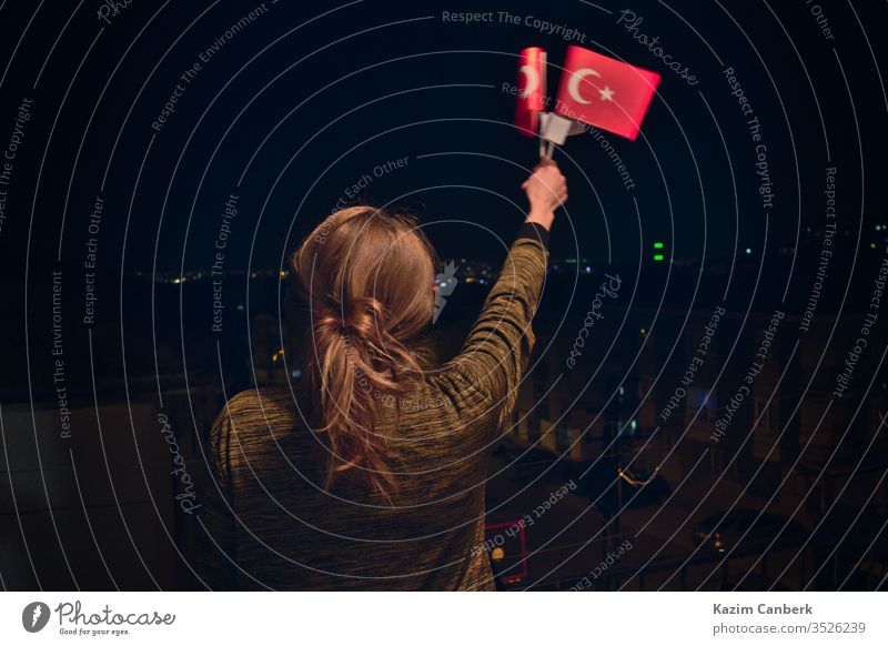Türkische Frau hält, schwenkt nachts türkische Flaggen zur Feier des 23. April Kindertages Fahne Türkische Flagge winkend Ankara Truthahn Nacht 23 nisan