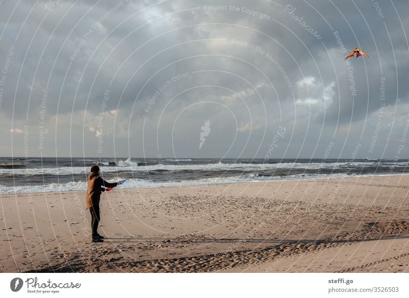 Mann lässt Drachen steigen am Strand drachensteigen Lenkdrachen Sturm Küste Dänemark Hvide Sande Junger Mann Nordsee Nordseeküste Strandleben Sandstrand Wellen