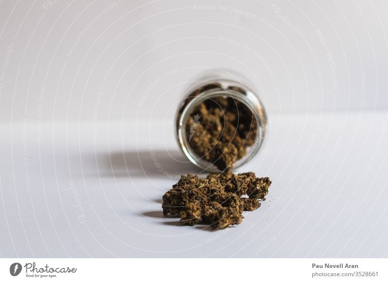 Ein Glas mit weißem Cannabis auf weißem Hintergrund Kraut Medizin Marihuana Sucht Dope ungesetzlich Marihuana / CBD cbd Textfreiraum Medikament ganja grün