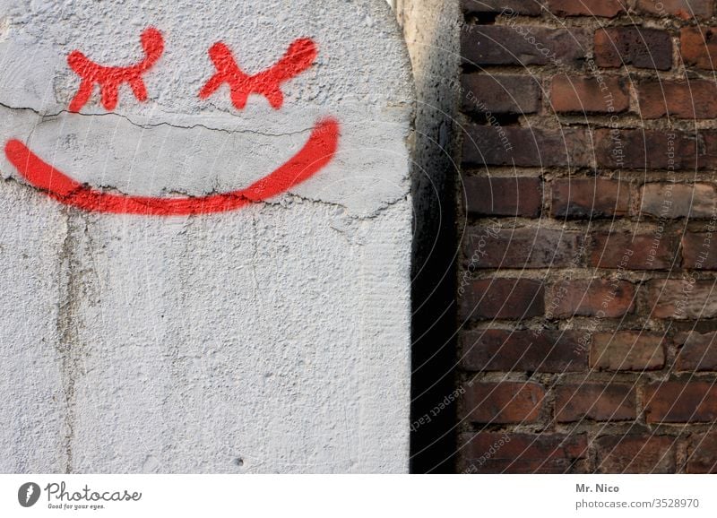 Augen zu und lächeln Mauer Smiley Graffiti rot Backsteinwand Lächeln Mund augen geschlossene Augen verputzt weiß Wand abstrakt Zeichen Fassade dreckig Fuge