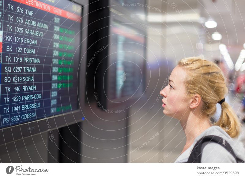 Passagier schaut auf die Fluginformationstafel. Flughafen Zeitplanung Information Anzeige reisen Frau jung Ausflugsziel Abheben Tourist Gepäck Reisender Mädchen