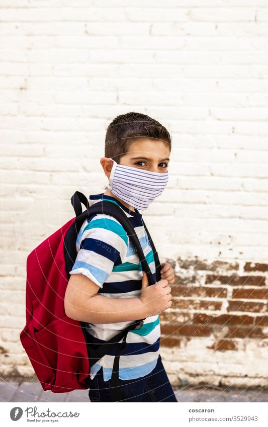 Kleiner Junge geht mit Schutzmaske zur Schule zurück zur Schule Rucksack Pflege Kind Kindheit Großstadt Klasse zugeklappt Hochschule Korona Corona-Virus