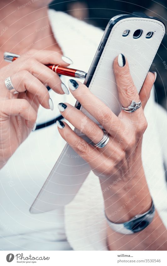 Frau mit Pen und Smartphone in der Hand und schön gestylten Fingernägeln Stylus Touchpen Hände manikürt Smartphone-Stift Eingabestift Digitale Mobilität