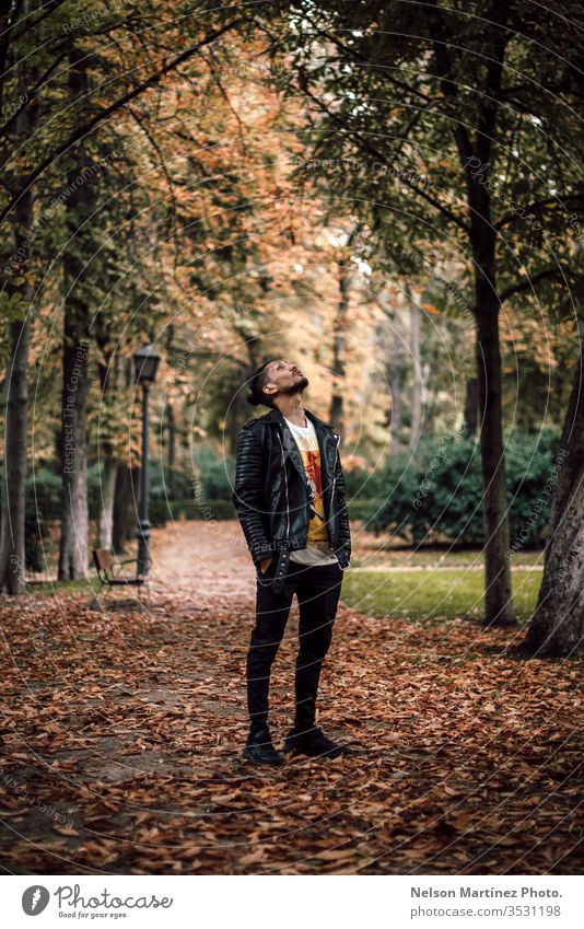 Porträt eines Mannes in einer Lederjacke, im Herbst im Park. Wald schwarz Bäume Herbstlaub hispanisch Natur Tag Außenaufnahme Farbfoto