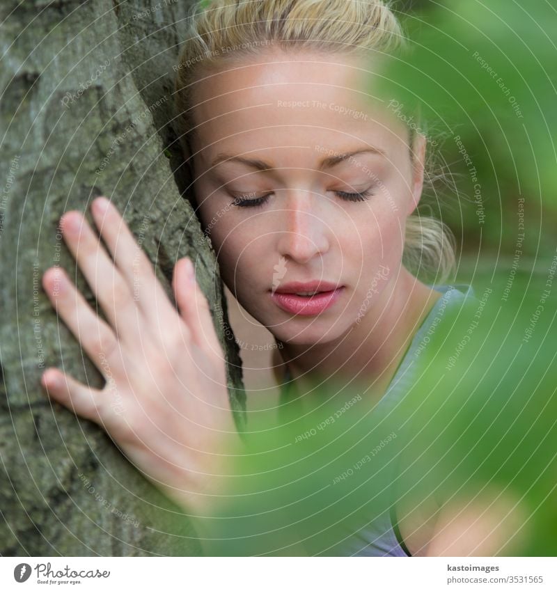 Junge Frau umarmt einen Baum. Umarmung umarmend hugger Umarmen Wald Harmonie Kofferraum Gleichgewicht geistig Spiritualität Arme zuhören Person Holz grün Natur