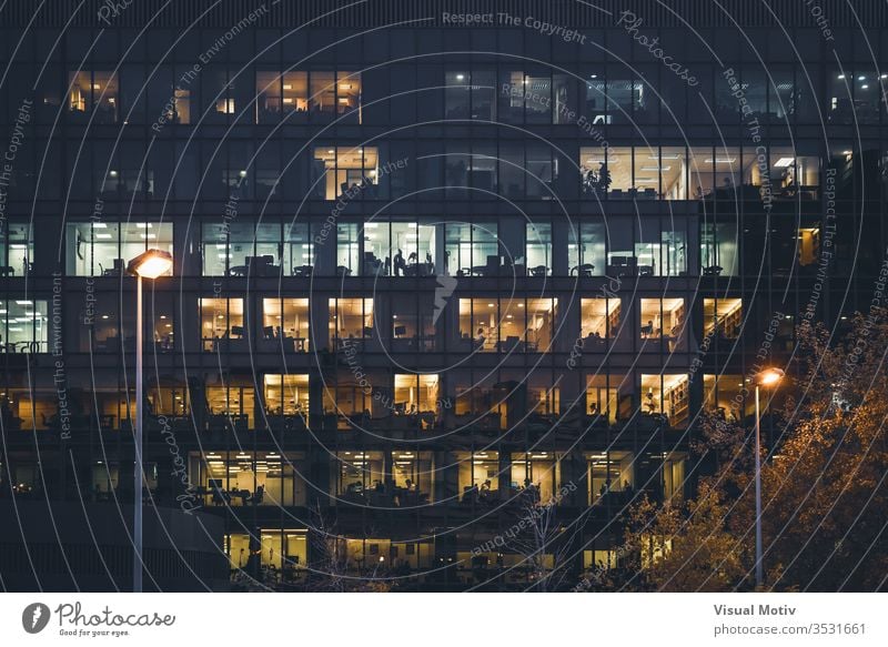 Beleuchtete Fenster eines Bürogebäudes bei Nacht Gebäude Lichter beleuchtet Reihen frontal breit Straßenlaternen Farbe Außenseite im Freien Großstadt urban