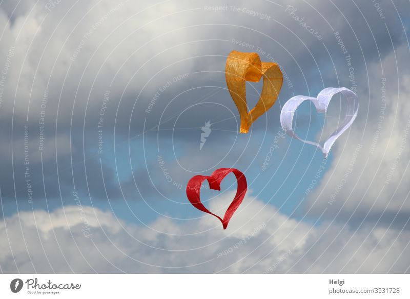 Dreiklang | drei Papierdrachen in Form von Herzen fliegen im Wind vor blau-grauem Himmel Drachen Wolken Liebe Farbfoto Menschenleer Tag Romantik Verliebtheit
