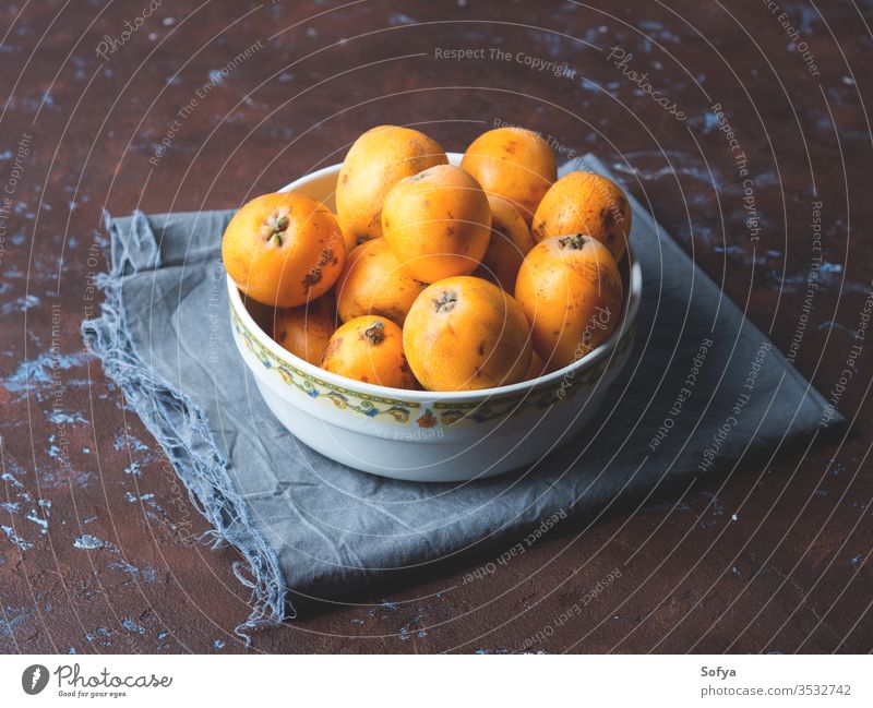 Loquat Japanische Mispelfrucht auf dunklem Hintergrund loquat eriobotrya japonica organisch Frucht Vitamin frisch orange Nahaufnahme lecker roh süß Natur