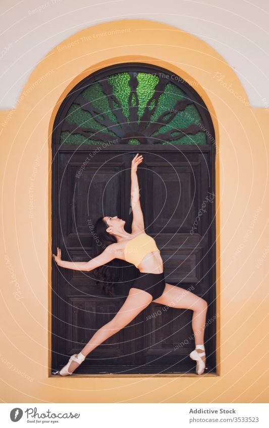 Ballerina tanzt an einer Ziertür Frau Tanzen Balletttänzer Anmut Konzept Tür Gebäude Ornament jung schlank elegant Arm angehoben Außenseite ausführen Tänzer