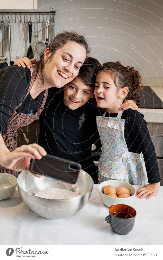 Mutter nimmt Selbstgebackenes mit Kindern während der Backwarenzubereitung Selfie Koch Gebäck heimwärts Küche Smartphone Handy Lächeln Glück Liebe Zusammensein