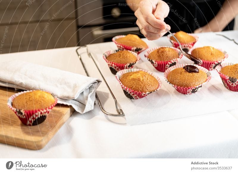 Ernte-Hausfrau schmiert Zuckerguss auf Törtchen Zuckerguß Cupcake Schliere Koch Küche heimwärts Löffel Frau gebacken Gebäck Lebensmittel Tradition selbstgemacht