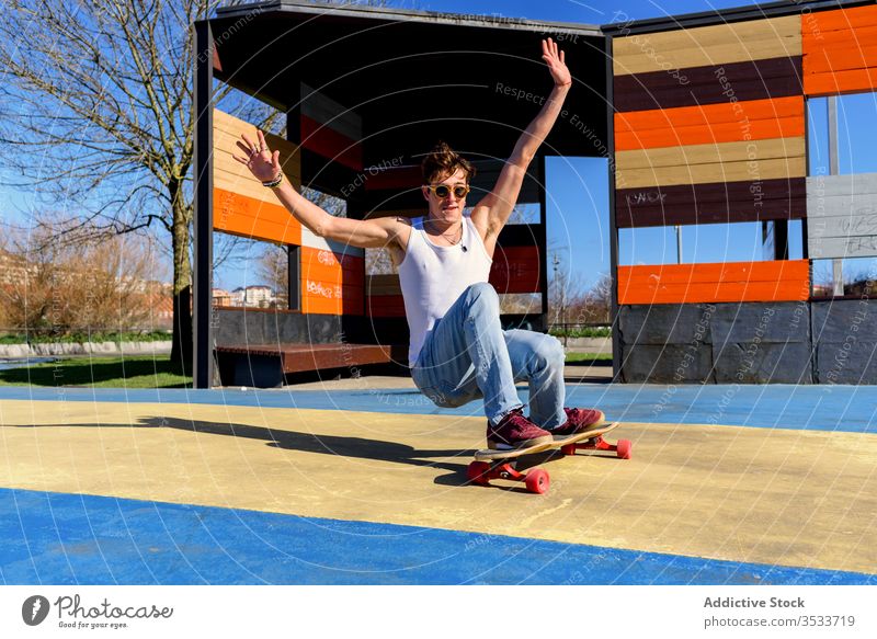 Junger Mann fällt vom Skateboard fallen Mitfahrgelegenheit Trick Sportpark Hipster Arm angehoben urban Großstadt männlich Skater Straße Energie Hobby sonnig