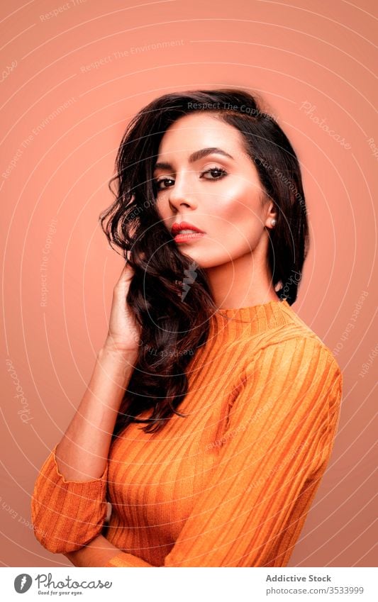 Sinnliches weibliches Modell im orangefarbenen Outfit Frau Stil selbstbewusst sinnlich Farbe hell lebhaft jung trendy lässig farbenfroh Dame schön Schönheit