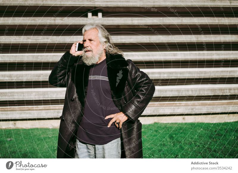 Älterer Mann benutzt Smartphone beim Stadtbummel älter Großstadt Hipster schlendern benutzend männlich Senior ernst gealtert besinnlich modern nachdenklich