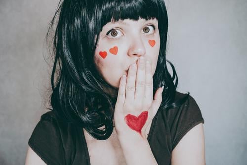 Wunderschönes Porträt einer jungen Frau mit roten Herzen im Gesicht Liebe Schönheit hübsch Kunst künstlerisch Valentinsgruß Valentinstag verliebt romantisch