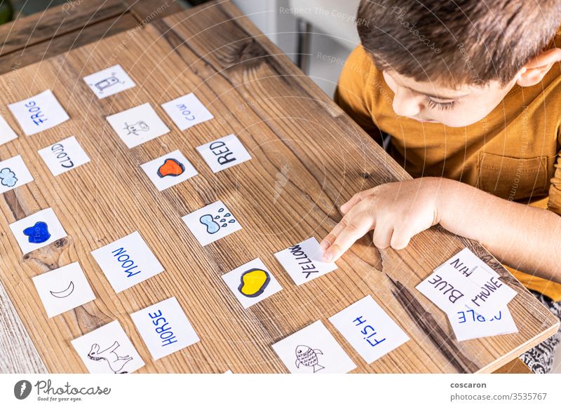 Kleines Kind, das mit Wort- und Bildkarten spielt. Alphabet zurück zur Schule Junge Karten Karikatur Kindheit Kinder Klassenraum Konzentration Coronavirus