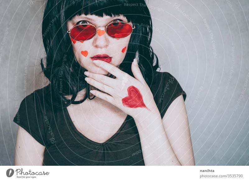 Cooles Porträt einer jungen Frau, die eine rote Brille trägt und voller roter Herzen ist Liebe Schönheit hübsch Gesicht Kunst künstlerisch Valentinsgruß