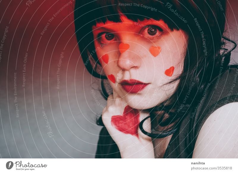 Künstlerisches Porträt einer jungen Frau mit rotem Herz-Make-up und bedeckt von einem roten Farbverlauf Liebe Schönheit hübsch Gesicht Kunst künstlerisch