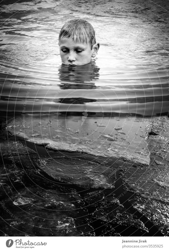 Junge badet im eisigen Wasser baden See Eis Schwimmen & Baden Im Wasser treiben Wellen Schwarzweißfoto Reflexion & Spiegelung Urlaub stille silence Monochrom