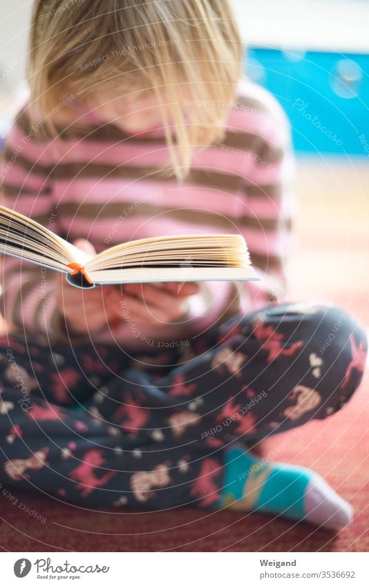 Kind mit Buch lesen Grundschule lernen Lernender Grundschulkind Lektüre Ruhe Literatur Mädchen Ferien Homeschooling Langeweile Konzentration Unterricht Schule