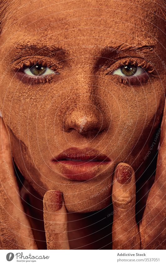 Weibliches Modell mit Schokolade im Gesicht Frau Pulver Gesicht berühren Konzept Deckung Leckerbissen sinnlich Vorschein jung schön Menschliches Gesicht